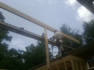 Carpenter setting a ridge beam over a new addition frame — Ice Dam Removal by Roofing Brothers in Hatboro
