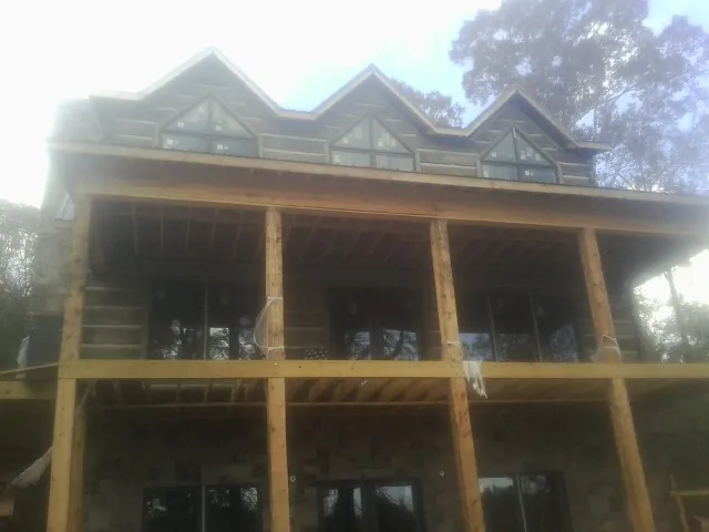 Dormers and porch framing on a large log home under construction — Roof Coating work by our crew in Hatboro